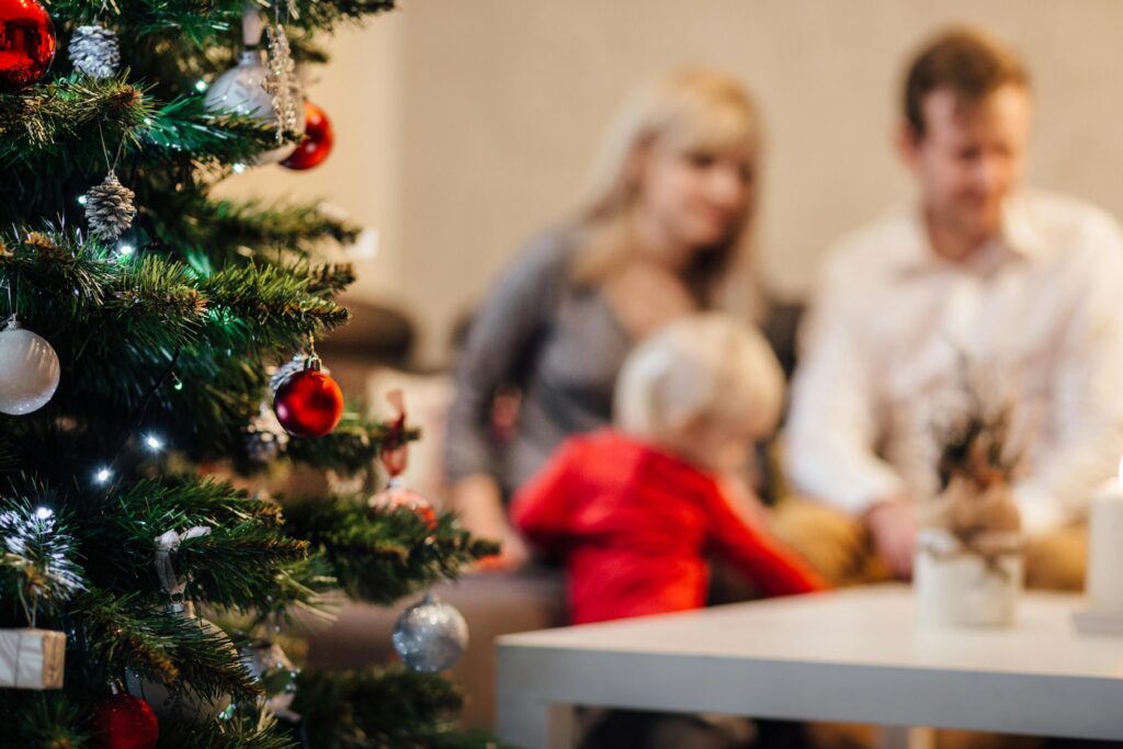 A cozy family gathering by the Christmas tree, enjoying festive decorations.
